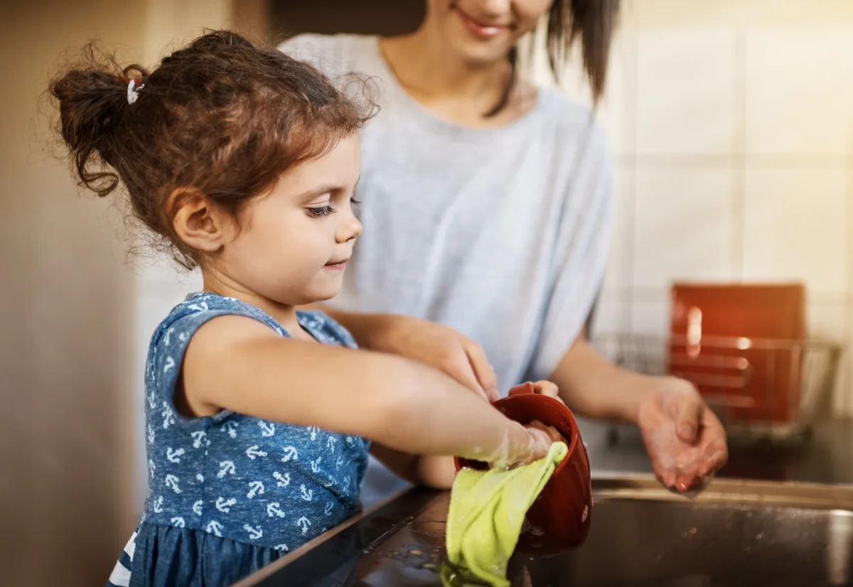 Child cleaning a cup as part of a chore routine