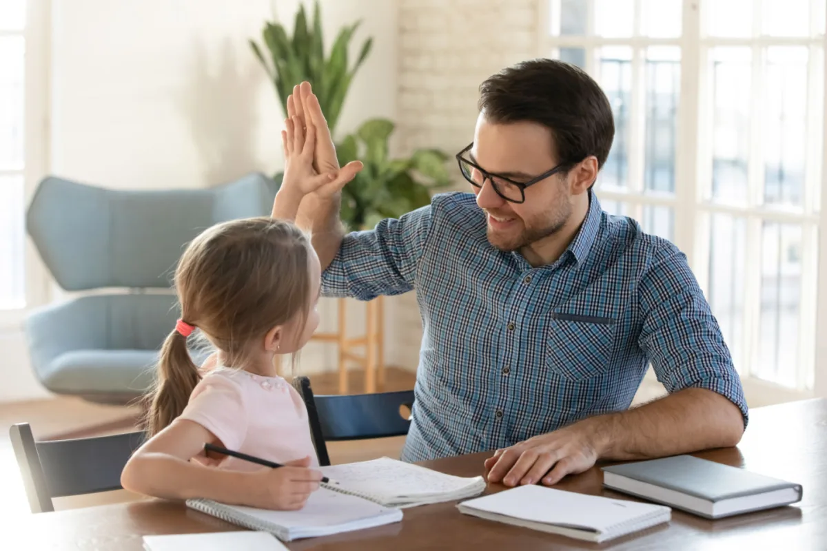 Dad high fiving child after finishing a chore