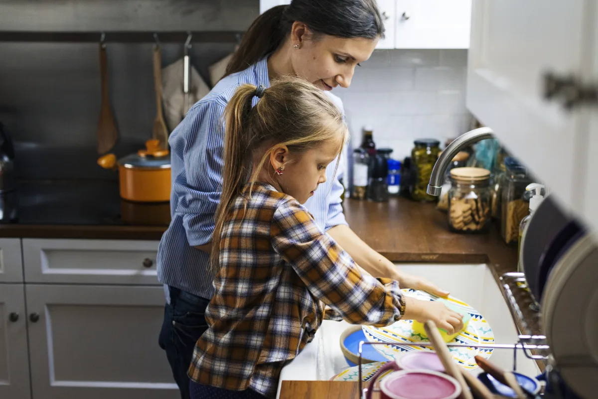 Child washing dishes as a household chore