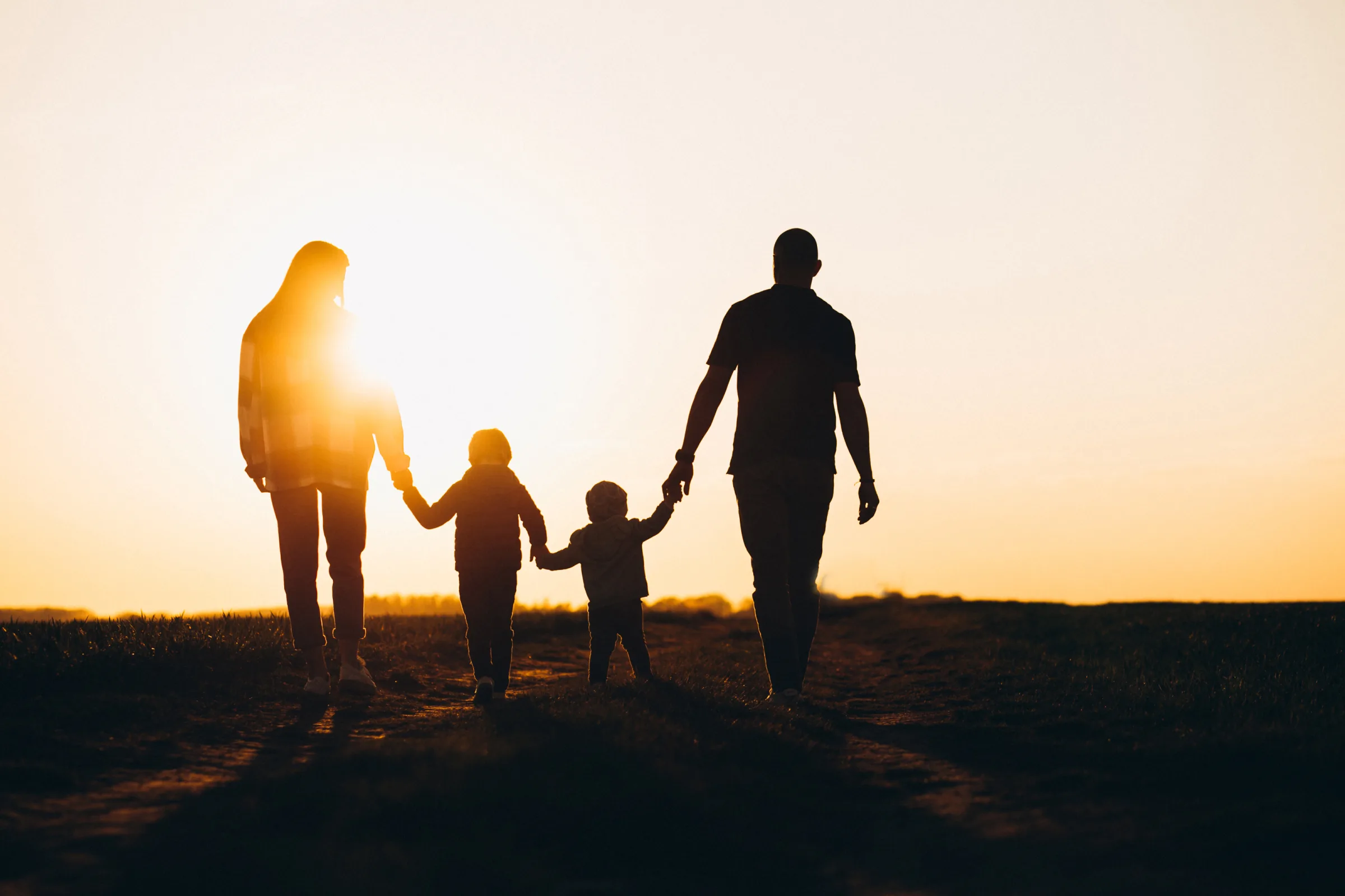 Happy family jumping together at sunset